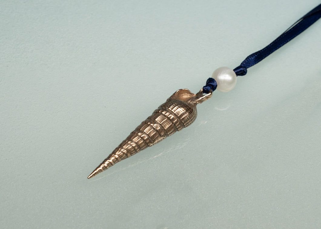Decorative pendant with a pearl on a blue cord against a light gray background