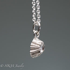 close up side view of cast silver barnacle necklace in polished finish by hkm jewelry