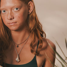 Load image into Gallery viewer, Woman with red hair wearing a necklace with a pendant against a neutral background
