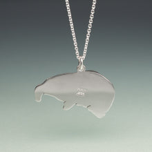 Load image into Gallery viewer, Silver pendant shaped like a manatee on a chain against a gradient background
