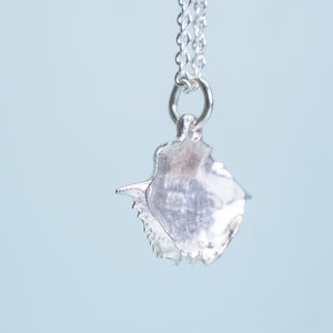 side view of baby blue crab carapace necklace in polished sterling silver by hali maclaren of hkm jewelry