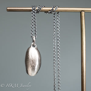 back view of cast atlantic bubble shell bulla striata necklace in oxidized sterling silver by hkm jewelry