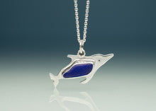 Load image into Gallery viewer, A silver dolphin pendant necklace with a textured blue inlay, suspended from a silver ball chain against a dark blue gradient background.

