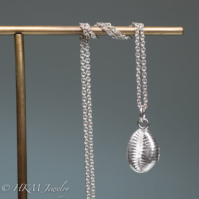 The Cowrie shell necklace is made from the molding and casting of a real found cowrie seashell in recycled silver by hkm jewelry