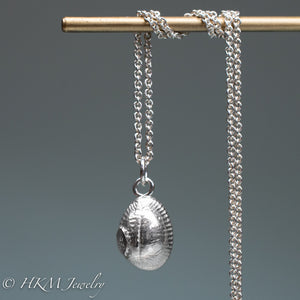 back of cast silver cowrie shell necklace by hkm jewelry