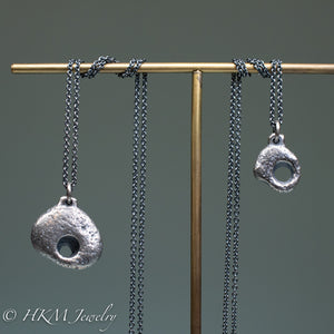 small and large sized hag stone necklaces cast in sterling silver by hkm jewelry in oxidized finish