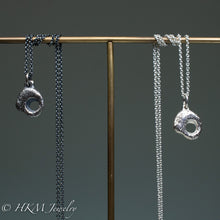 Load image into Gallery viewer, close up of hag stone necklaces cast in sterling silver by hkm jewelry in oxidized and polished finishes
