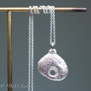 close up of hag stone necklace cast in sterling silver by hkm jewelry in polished finish