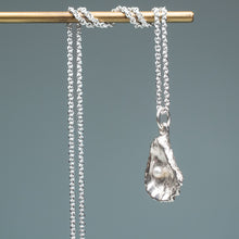 Load image into Gallery viewer, side view of Silver oyster pearl necklace kittens pawpendant necklace on a gray background hkm jewelry 
