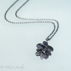bottom view of cast silver hemlock pine cone necklace by hkm jewelry in oxidized finish