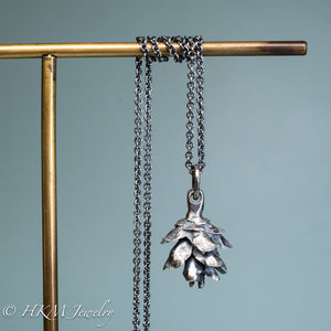 cast silver hemlock pine cone necklace by hkm jewelry in oxidized finish