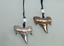 Load image into Gallery viewer, Two shark tooth ornaments on blue strings with pearls against a light gray background
