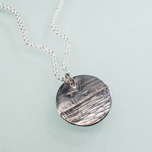 Load image into Gallery viewer, sedge island workshop marsh necklace with shorebirds in sterling silver by hkm jewelry laying on blue background
