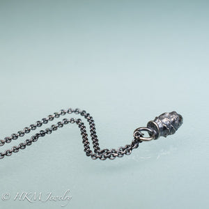 top view of cast silver mini pinecone necklace by hkm jewelry in oxidized finish
