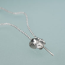 Load image into Gallery viewer, mini cast silver horseshoe crab necklace by hali maclaren of hkm jewelry laying on blue background
