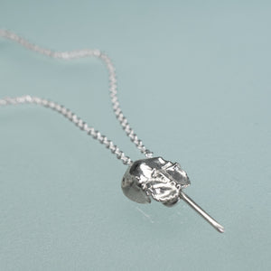 mini cast silver horseshoe crab necklace by hali maclaren of hkm jewelry laying on blue background