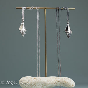  juvenile queen conch necklaces in oxidized and polished silver on brass and coral jewelry stand display by hkm jewelry