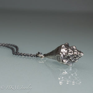 close up  view of juvenile queen conch necklace in oxidized silver by hkm jewelry