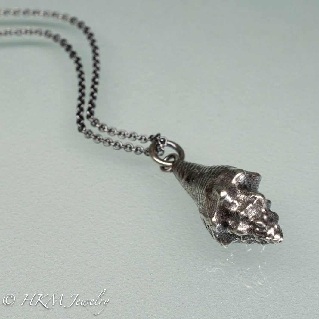close up back view of juvenile queen conch necklace in oxidized silver by hkm jewelry