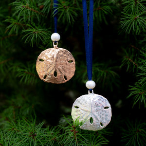 cast bronze and silver sand dollar ornaments found in stone harbor nj with freshwater pearl and navy blue satin ribbon by hkm jewelry on evergreen tree