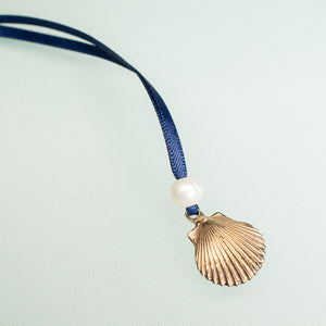 cast bronze ornament with freshwater pearl and navy blue satin ribbon by hkm jewelry