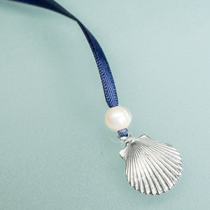 cast silver shell from cape may NJ scallop ornament with freshwater pearl and navy blue satin ribbon by hkm jewelry