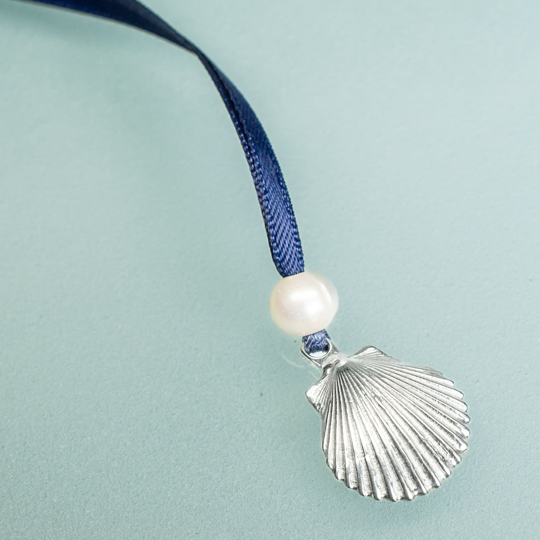 cast silver shell from cape may NJ scallop ornament with freshwater pearl and navy blue satin ribbon by hkm jewelry