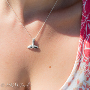 top side of silver whale tail necklace by hkm jewelry on model
