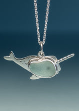 Load image into Gallery viewer, A sterling silver narwhal pendant necklace featuring a smooth, light green sea glass inlay, suspended from a silver chain against a dark blue gradient background.
