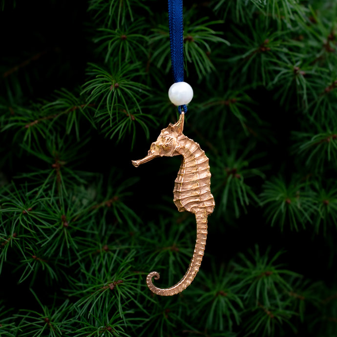 cast bronze seahorse ornament with freshwater pearl and navy blue satin ribbon by hkm jewelry