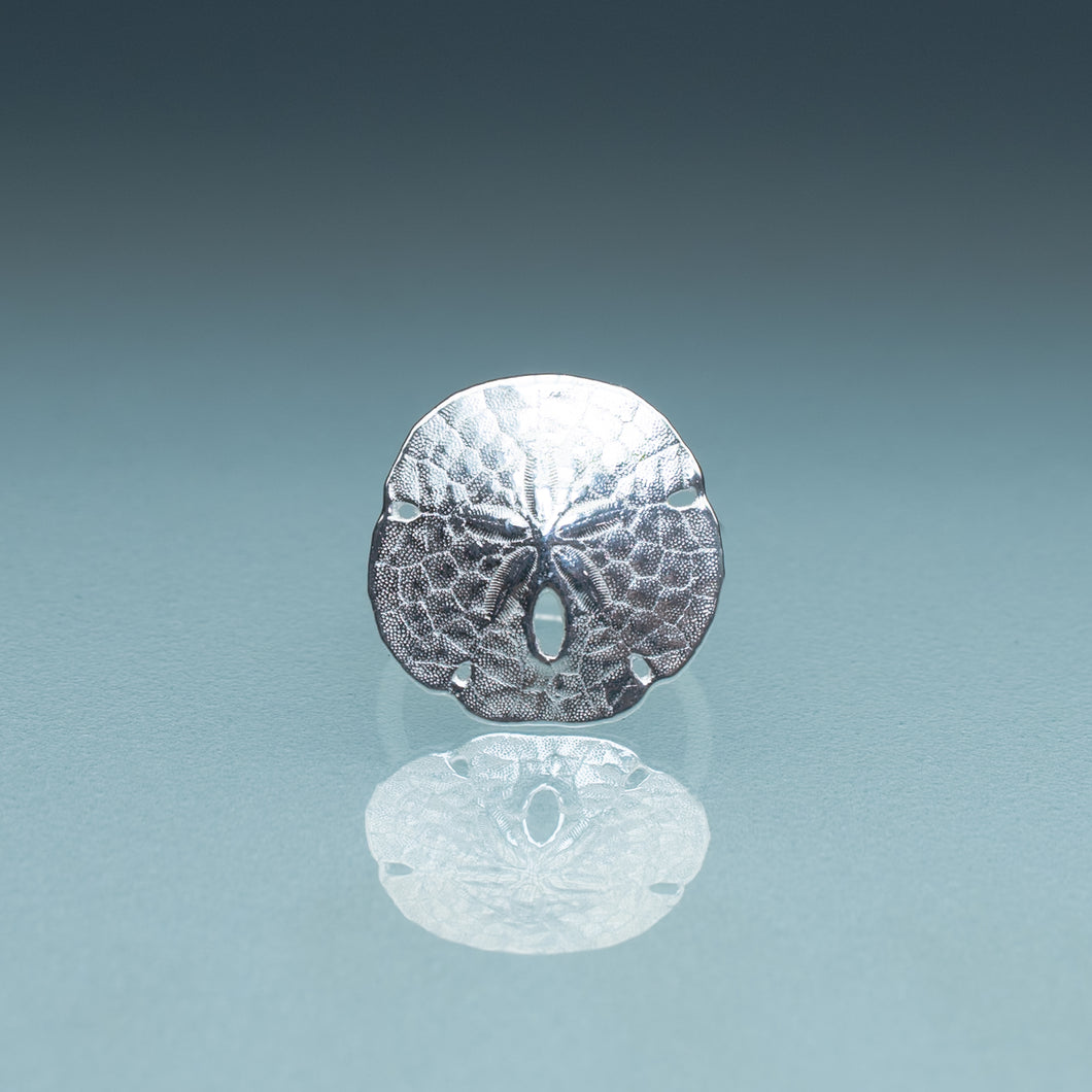 silver sand dollar ring on blue green gradient background