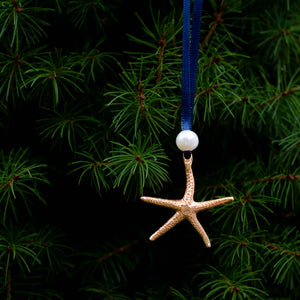 cast bronze starfish ornament with freshwater pearl and navy blue satin ribbon by hkm jewelry