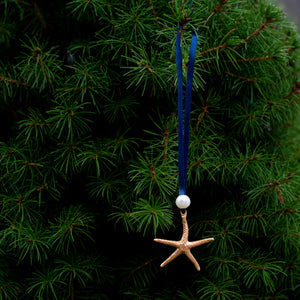 cast bronze starfish ornament with freshwater pearl and navy blue satin ribbon by hkm jewelry