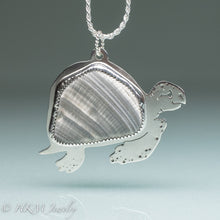 Load image into Gallery viewer, hand sawn and pierced sterling silver sea turtle necklace with fossilized clam shell shard bezel setting
