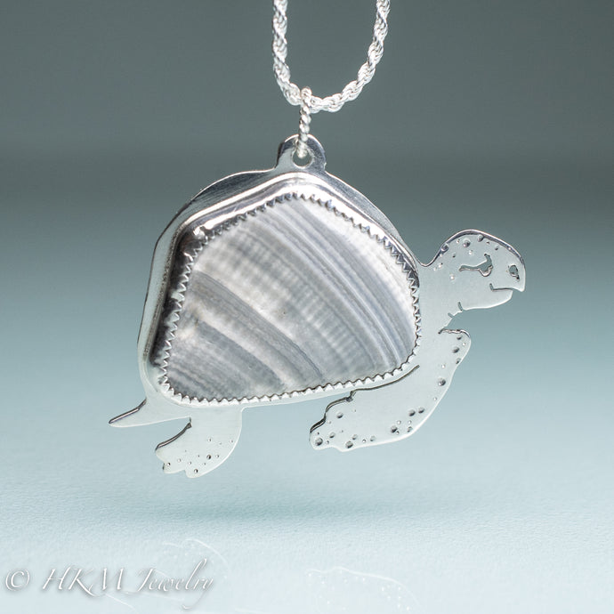 hand sawn and pierced sterling silver sea turtle necklace with fossilized clam shell shard bezel setting