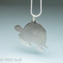 Load image into Gallery viewer, underside of hand sawn and pierced sterling silver sea turtle necklace with fossilized clam shell shard bezel setting by hkm jewelry stamped 925
