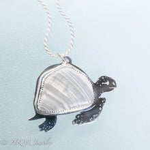 Load image into Gallery viewer, hand sawn and pierced sterling silver sea turtle necklace with fossilized clam shell shard bezel setting by hkm jewelry
