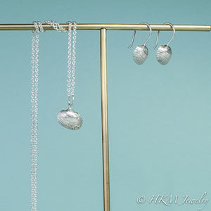 side view of ark clam seashell drop earrings in silver with matching ark clam necklace