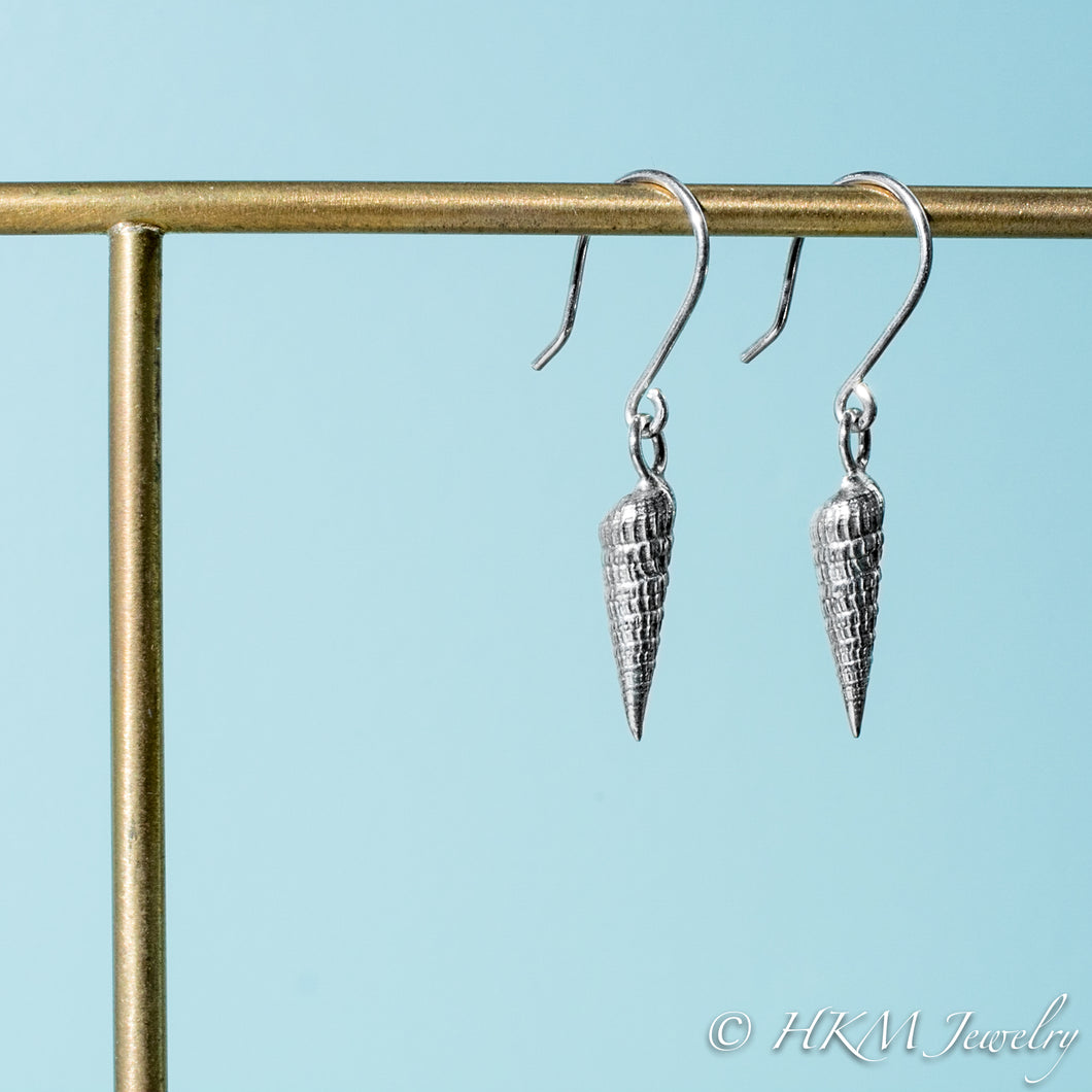 side close up view of auger snail shell dangle earrings in polished silver by hkm jewelry 