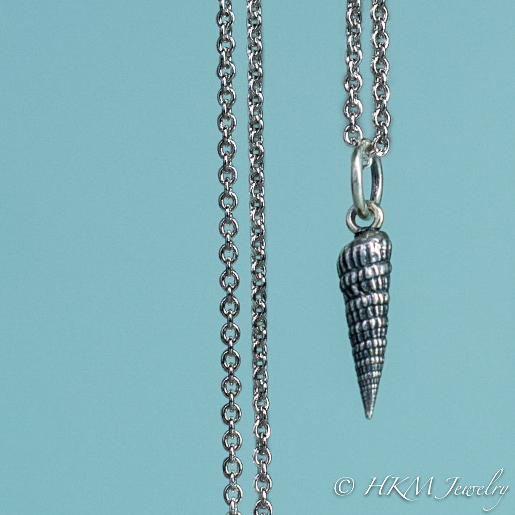 close up front view of the auger snail shell necklace in oxidized silver by hkm jewelry