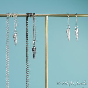 close up front view of auger snail shell dangle earrings and matching necklaces in polished and oxidized silver by hkm jewelry
