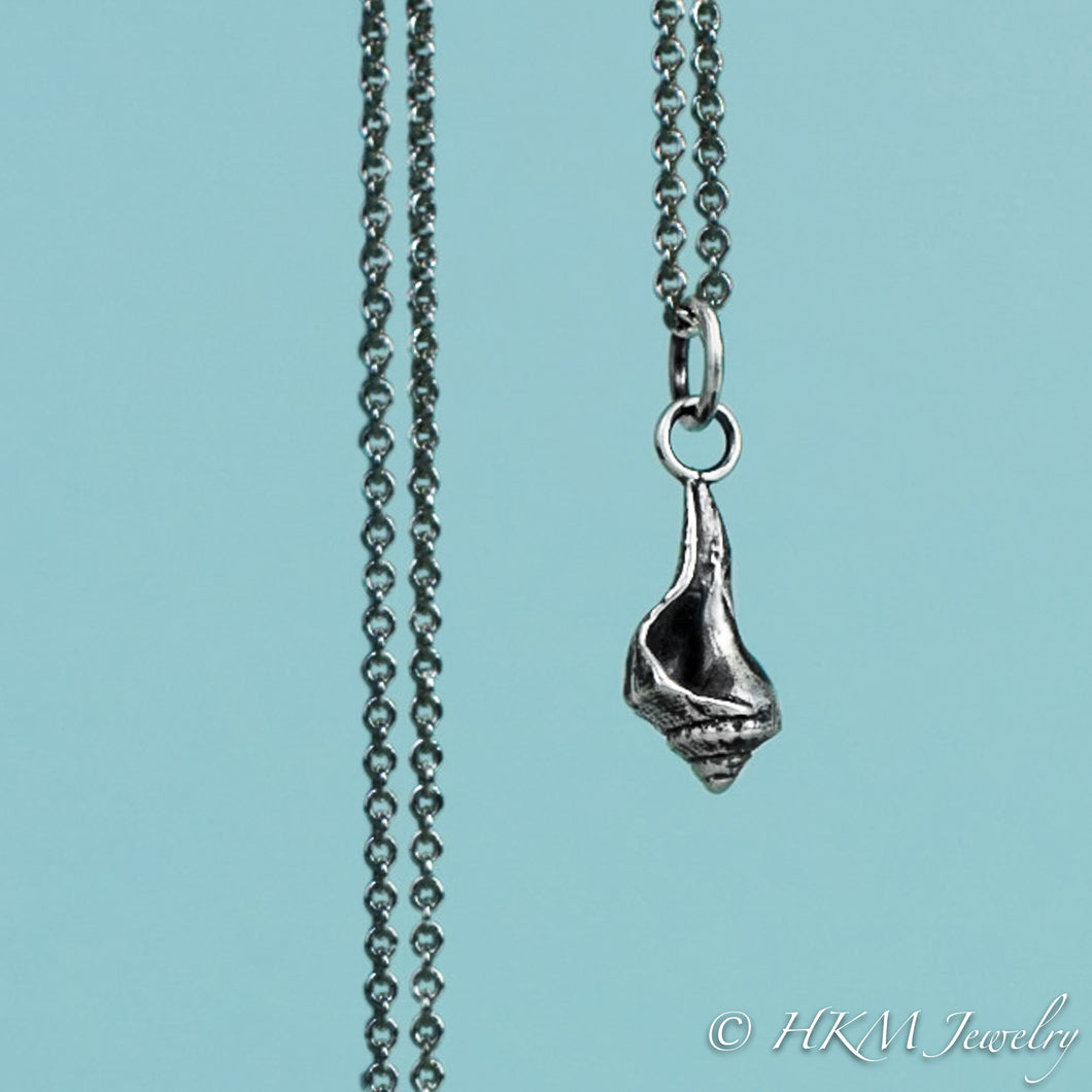 close up front view of baby knobbed whelk necklace in oxidized finish by hkm jewelry