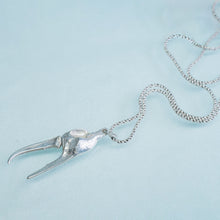 Load image into Gallery viewer, underside view of the cast fiddler crab claw necklace in recycled silver laying on a blue background by hkm jewelry

