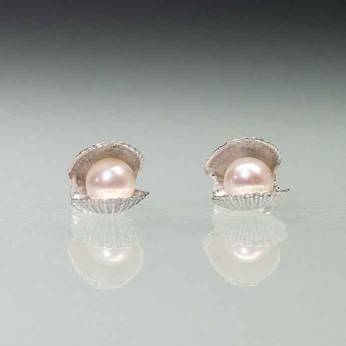 Mini scallop shell stud earrings cast in silver with freshwater pearls inside by Hali MacLaren of HKM Jewelry