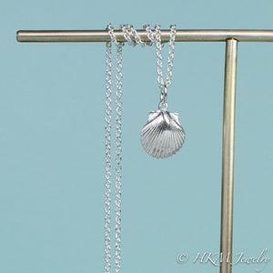 detail close up of small scallop shell necklace in polished sterling silver by hkm jewelry