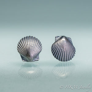 close up view of small scallop shell studs in oxidized sterling silver by hkm jewelry