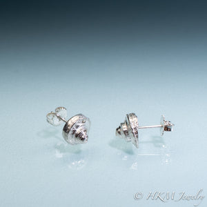 Side view of the Channeled Whelk Top Studs in sterling silver with Biggie Ear Nut Backs by Hali MacLaren of HKM Jewelry on blue ombre background.
