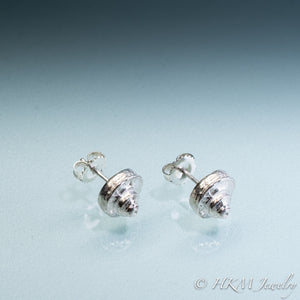 Side view of the Channeled Whelk Top Studs in sterling silver with Biggie Ear Nut Backs by Hali MacLaren of HKM Jewelry on blue ombre background.